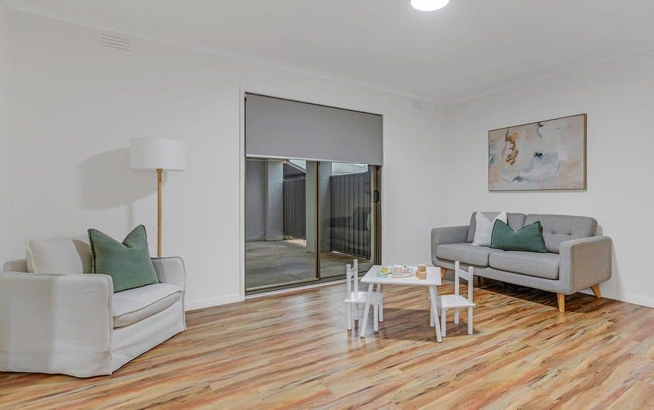 Living room styled for sale by Wisteria & Oak in Echuca, with pale sofas and a soft green cushion palette