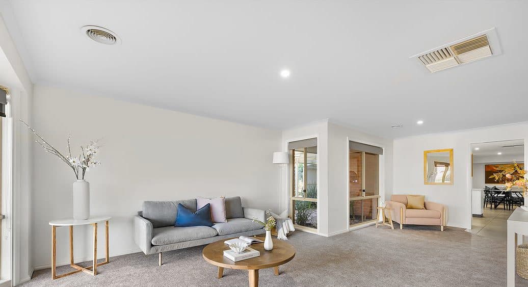 Living and dining space styled by Wisteria & Oak in Moama, with a wood fire, timber floors and a linen armchair